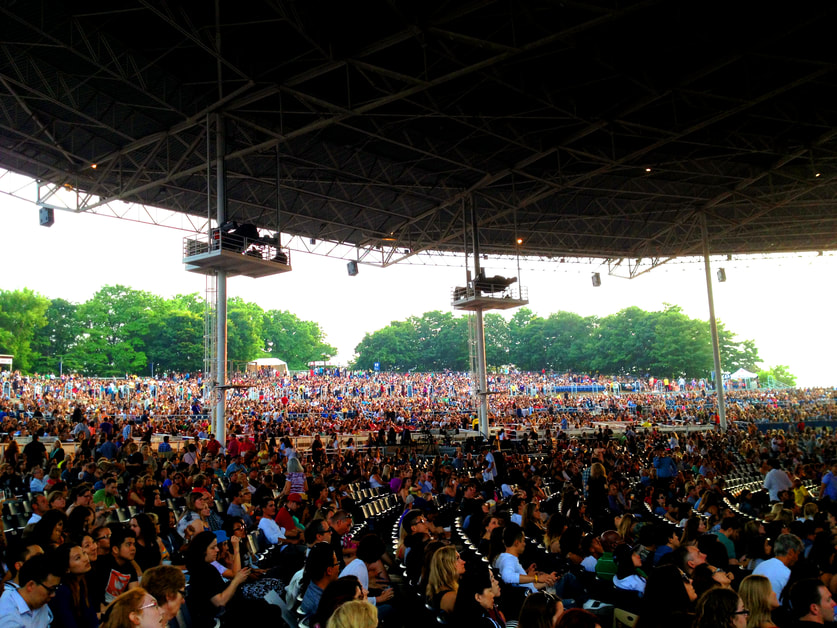 Crowds fill seats within the rounded area of the Budweiser concert venue © Unknown